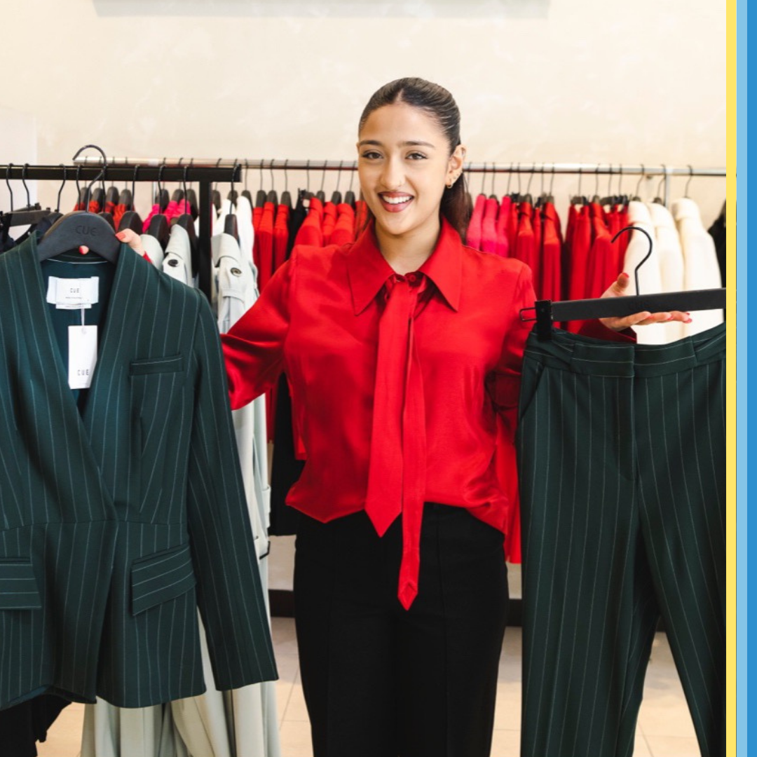 Women holding up an interview outfit option at a store.