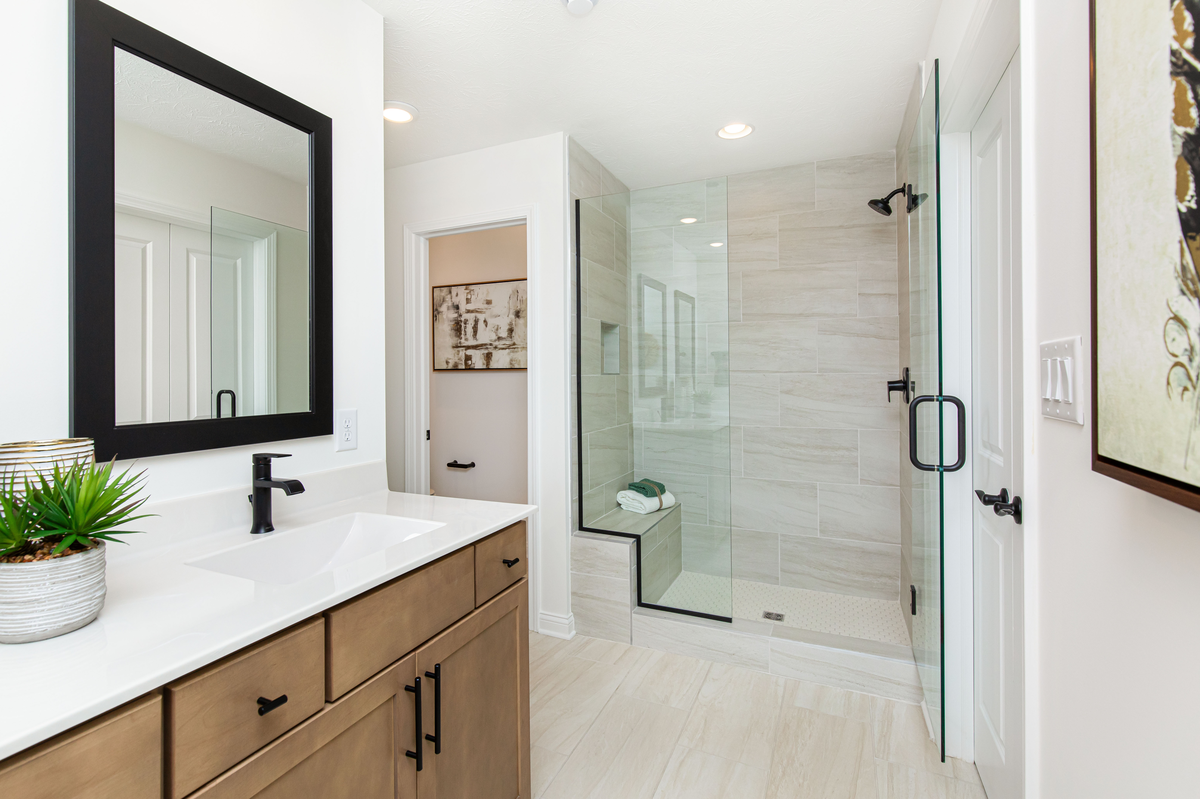 primary bathroom with tiled shower with bench  