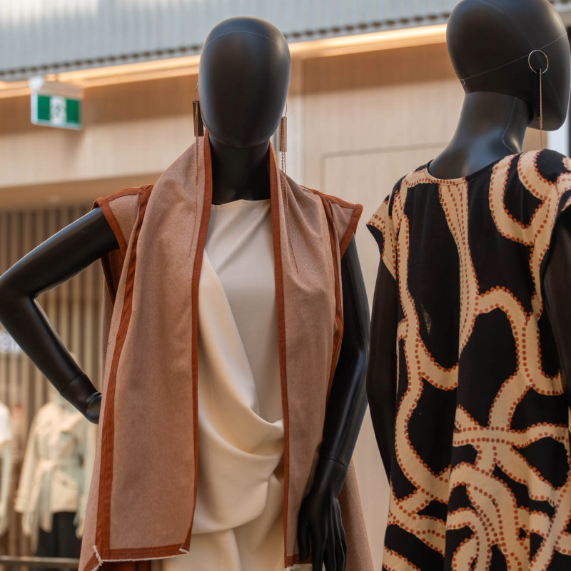Fashion display featuring garments from the EDITION x Sarrita King collaboration at Canberra Centre, with mannequins dressed in contemporary designs inspired by First Nations storytelling and artistic motifs, alongside a campaign display highlighting the collection and jewellery by Phoebe Porter.