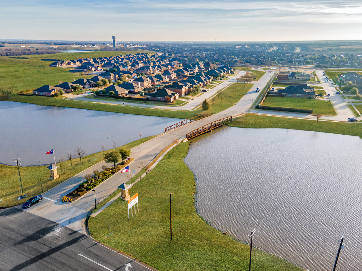 aerial of neighborhood entrance with lake