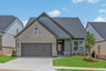 front of 1-story home with 2-car garage and brick