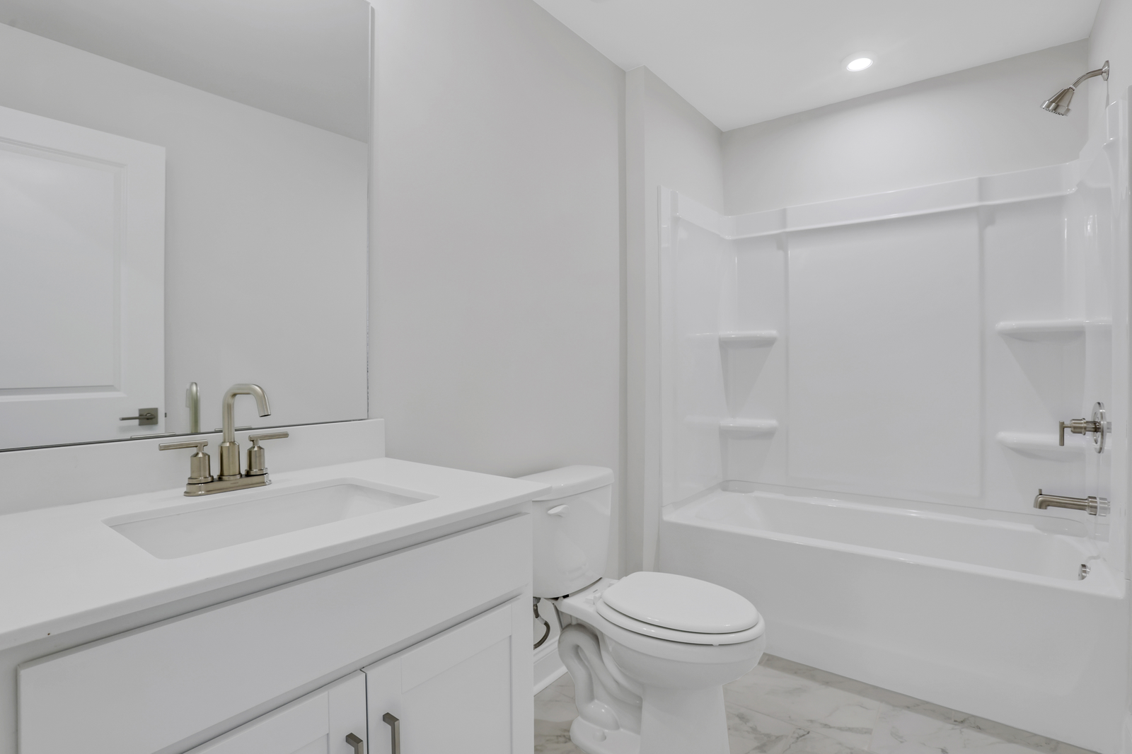 secondary bathroom with white cabinets and tile flooring