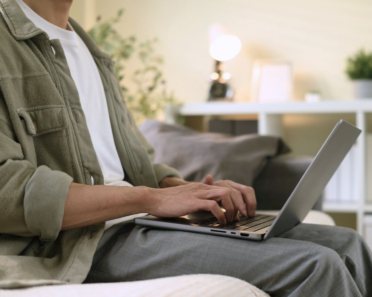 man sitting on a sofa with laptop on lap