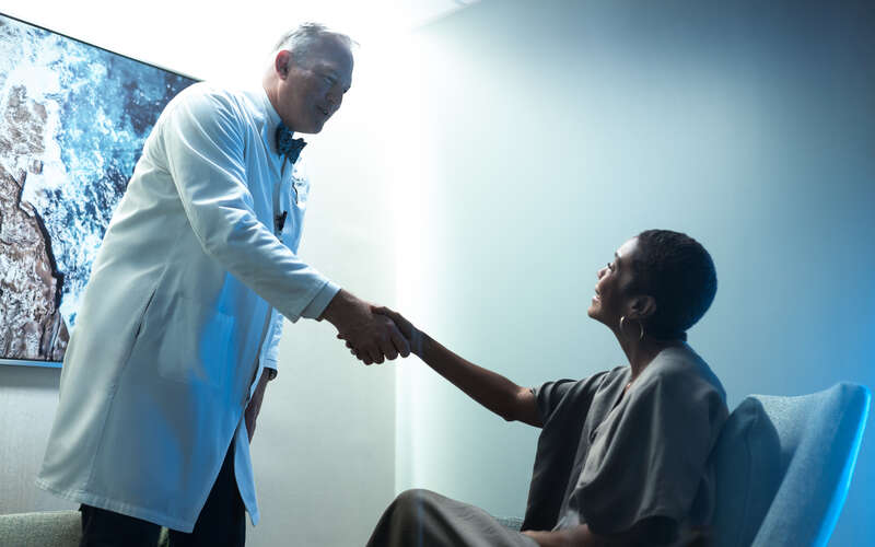 Dr. Robert Wenham greets a female patient