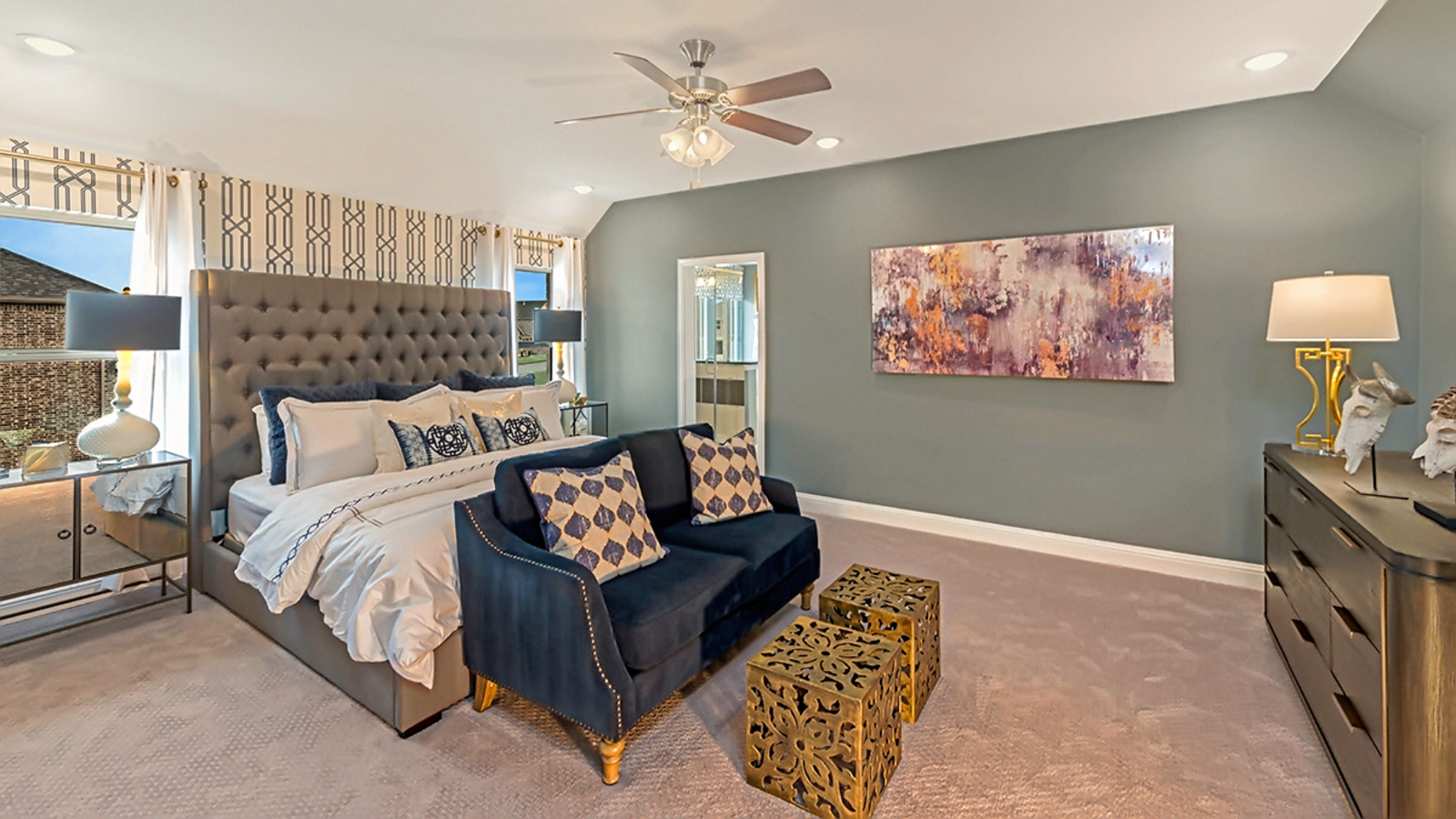 primary bedroom with carpet flooring, white trim, large windows, bed, and dresser