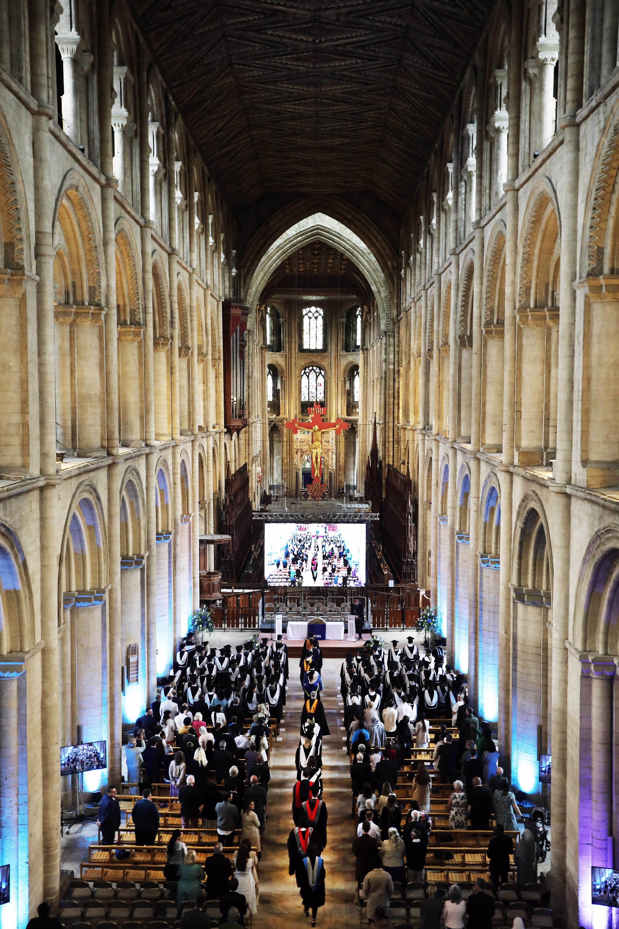 Wide view of a graduation procession inside a grand cathedral