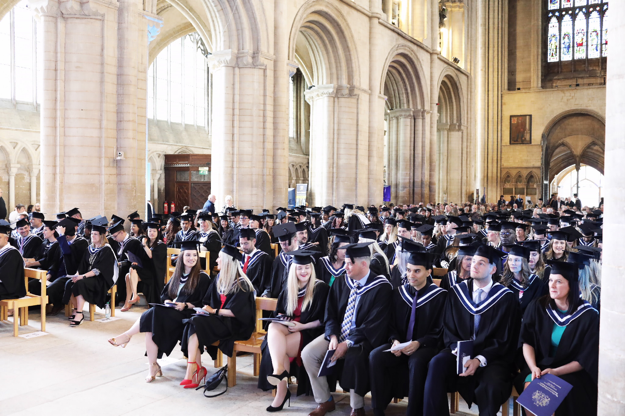 Wide view of graduates seated in rows inside the cathedral