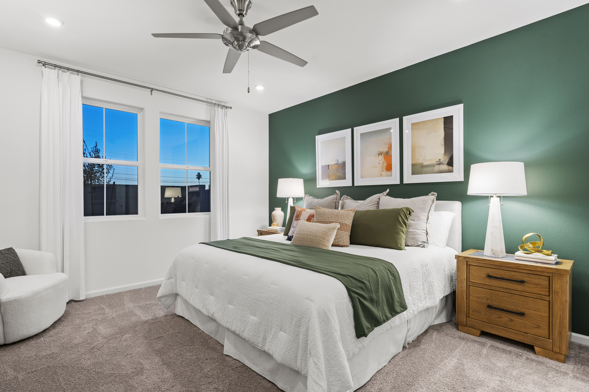 primary bedroom with large bed and accent wall