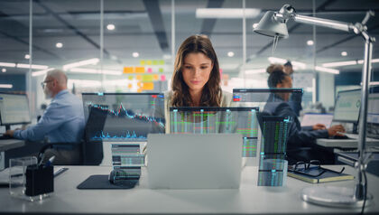 young happy businesswoman using laptop computer in modern office with colleagues