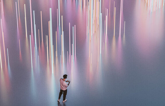 Man listening to music next to a light display