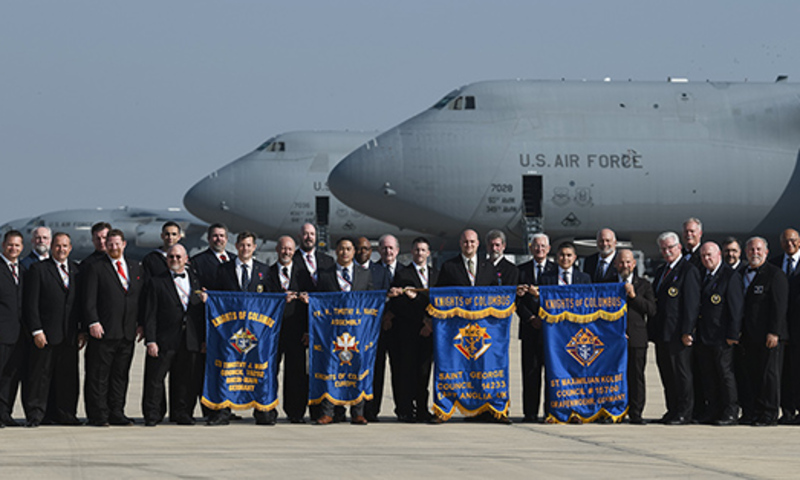 Knights of Columbus Supreme leaders pose for a photo in front of US Airforce cargo planes.