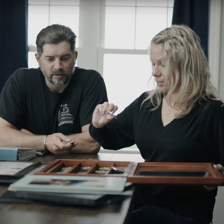 Man and women look through military award pins at a table