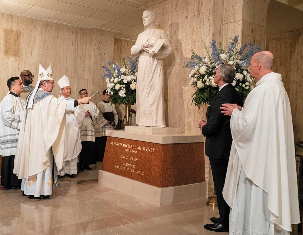 Cardinal Christophe Pierre, apostolic nuncio to the United States, blesses the new marble statue of Blessed Michael McGivney on Dec. 8, 2023, at the Basilica of the National Shrine of the Immaculate Conception in Washington, D.C. Supreme Chaplain Archbishop William Lori, Supreme Knight Patrick Kelly and rector Msgr. Walter Rossi (right) are looking on. (Photo by Matthew Barrick)