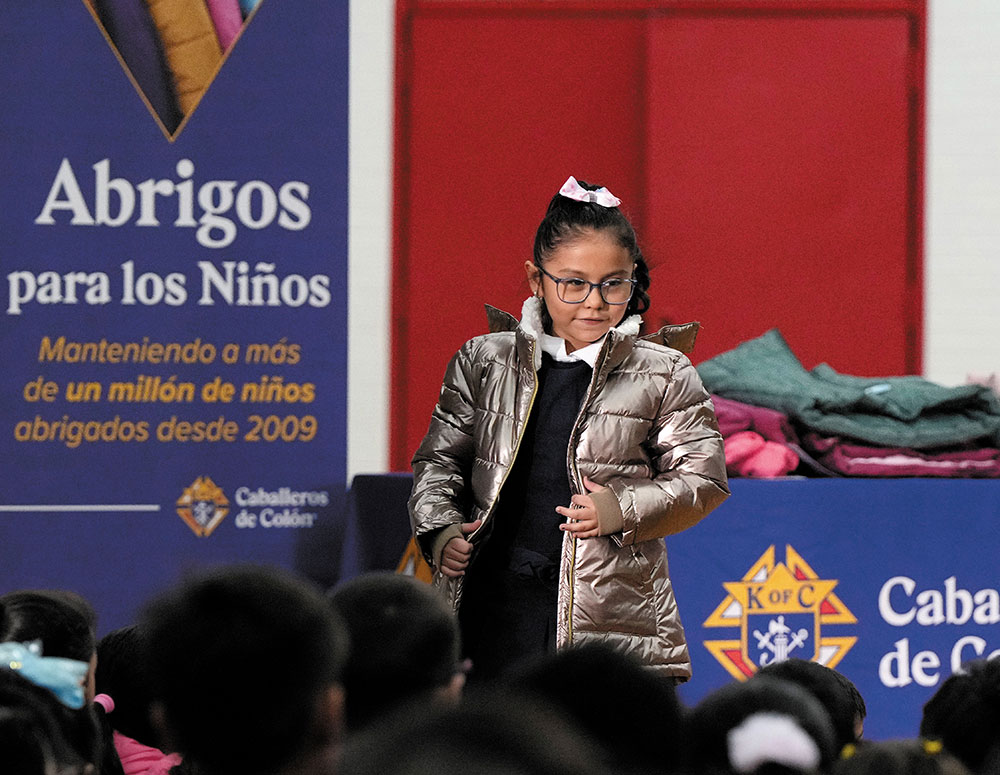 Lexi Cordova, a first grader at Annunciation Catholic School in Denver, wears a golden coat she received to mark the 1 million coats given away since Coats for Kids began in 2009. (Photo by Paul Haring)