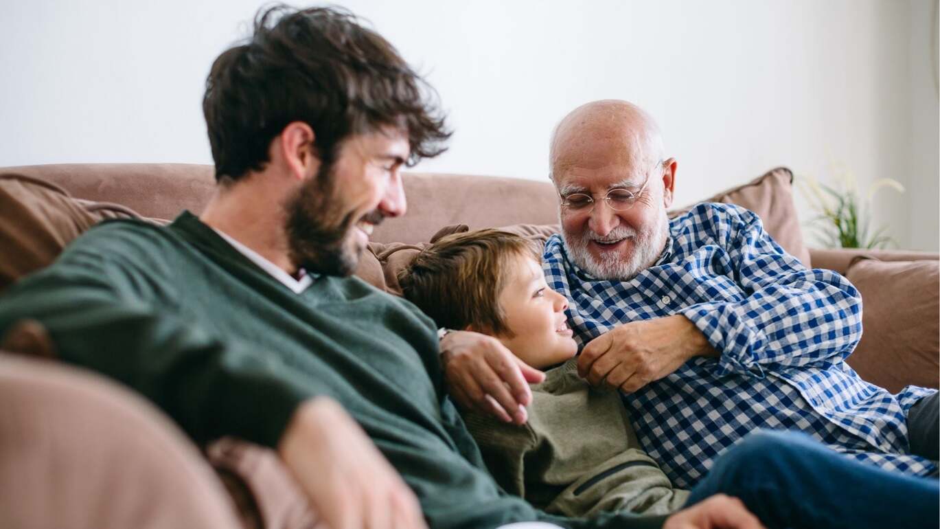 Dad sharing a hug with two children while holding a Father’s Day gift.