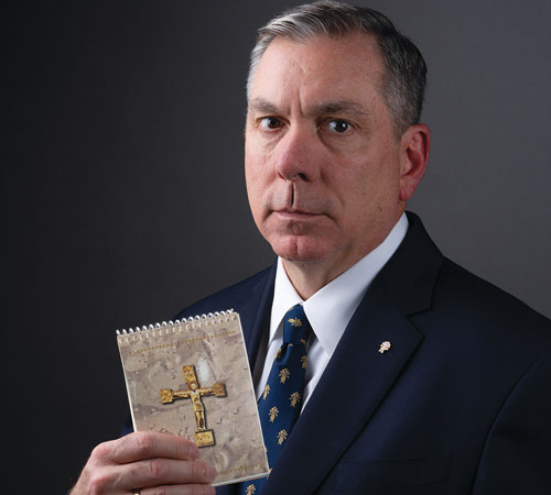 Supreme Master Michael McCusker shows the copy of Armed with the Faith he carried with him throughout his 2005-2006 deployment to Iraq with the Tennessee National Guard.