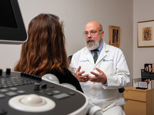 Dr. John Bruchalski, director of Tepeyac OB-GYN and a member of Padre Pio Council 10754 in Great Falls, Va., speaks with a patient in his Fairfax office. (Photo by Matthew Barrick)