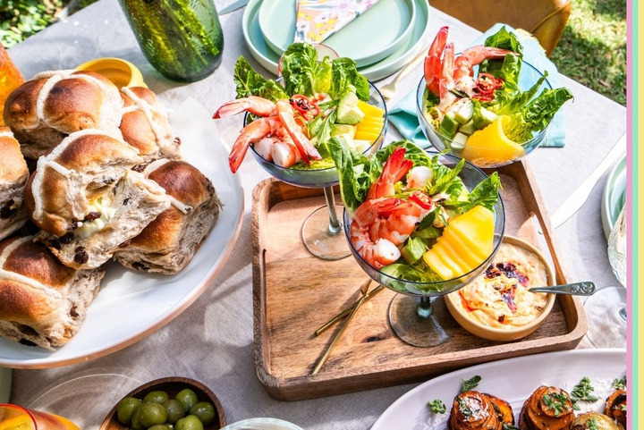 Table setting with prawn cocktails and hot cross buns