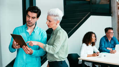 Business people looking at a smart device in a meeting room