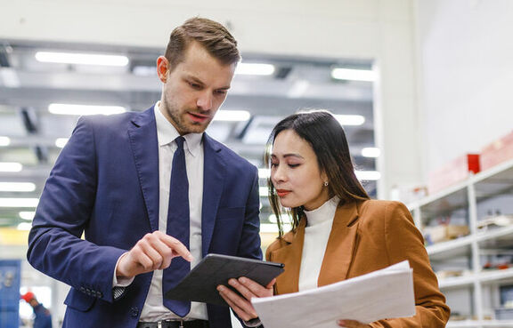 Manager giving instructions to a woman in a warehouse