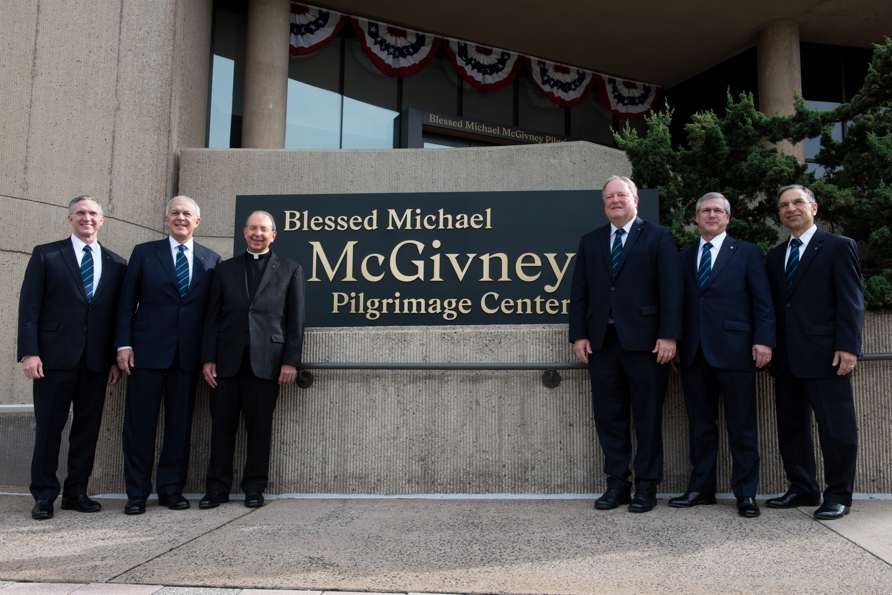 Knights of Columbus leaders stand flanking the new signage for the pilgrimage center dedicated to Blessed Michael McGivney on November 1, 2020.