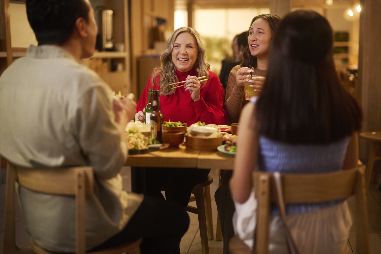 Family sitting in a booth with food and drink on the table