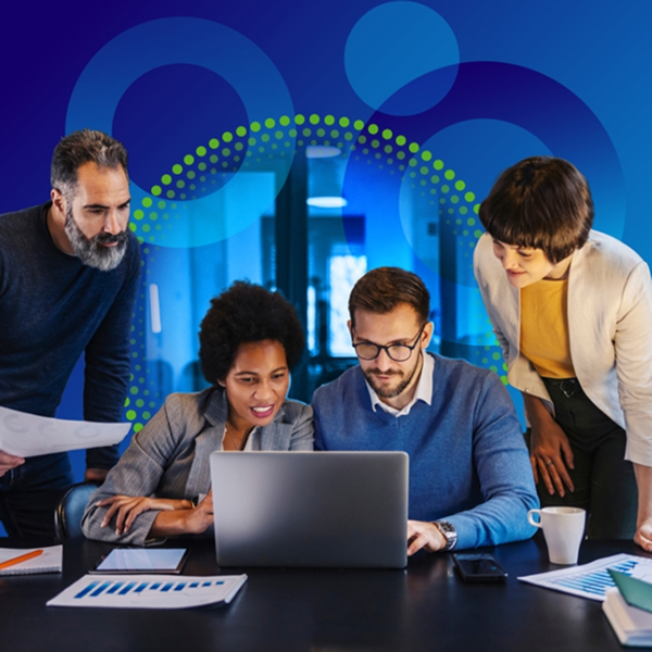 A group of four professionals—two men and two women—leaning over a laptop on a dark desk in a modern office, collaborating and looking intently at the screen. The image is overlayed with blue and green abstract circular shapes.