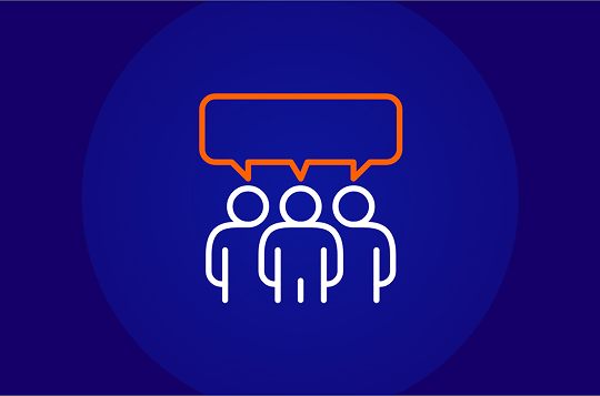 A white line-art icon on a dark blue background showing three stylized people standing shoulder-to-shoulder, with a large orange speech bubble hovering over their heads, symbolizing communication, teamwork, or collective effort.