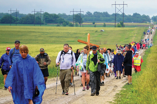 Participants the 14th annual Father Kapaun Pilgrimage walk down a country road