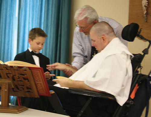 Michael Norum receives his first Communion from Father Stu