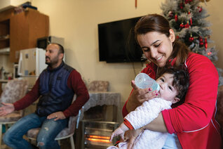 Soleen Sami Ibrahim feeds her baby in her family’s new apartment in McGivney House in Erbil, Iraq