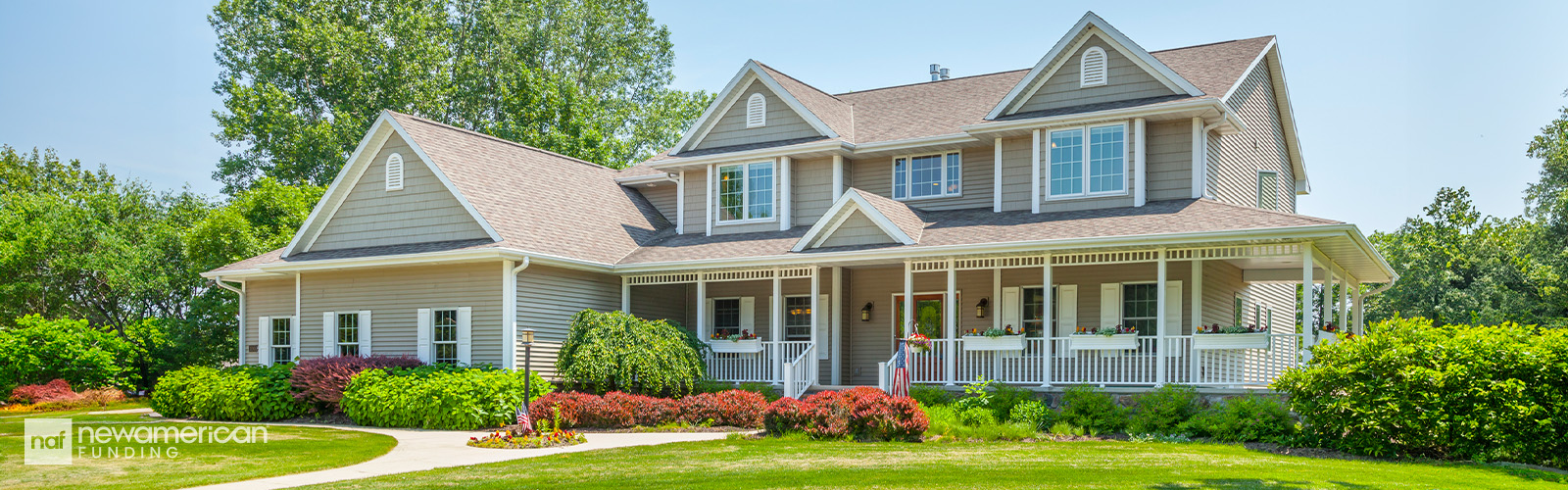 A nice two-story beige vinyl-paneled home sits in a well manicured lawn
