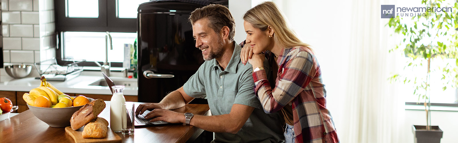 couple looking at a laptop in their kitchen