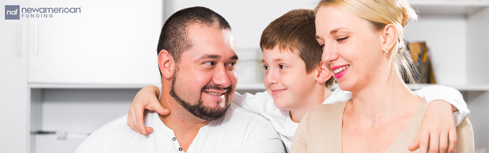A white man, woman, and child sit at a table talking and smiling