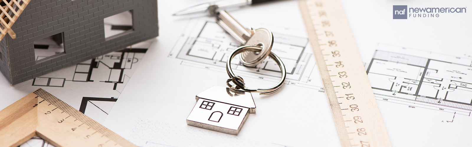 house keys sit on top of home construction plans