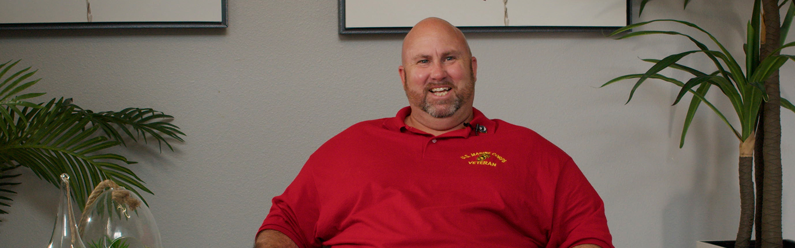 Man in a red shirt sitting in a chair