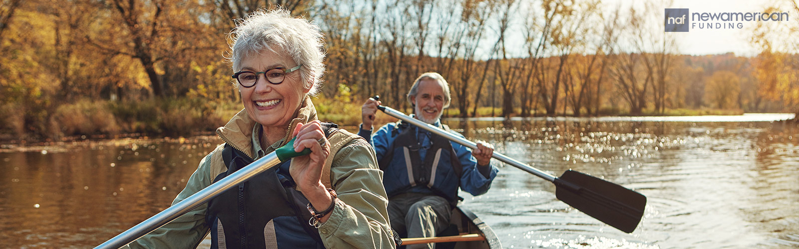 happy senior couple rowing a bow in the lake