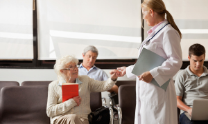 Zdravnica v čakalnici, polni pacientov - ko se naročate na pregled, je dobro vedeti, kaj vam omogoča napotnica za zdravniški pregled in kje.