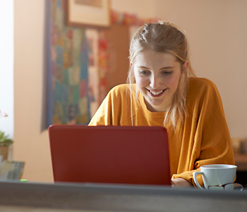 Mlada ženska na računalniku pripravlja svoj življenjepis in išče priložnosti za študentsko delo