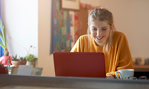 Mlada ženska na računalniku pripravlja svoj življenjepis in išče priložnosti za študentsko delo