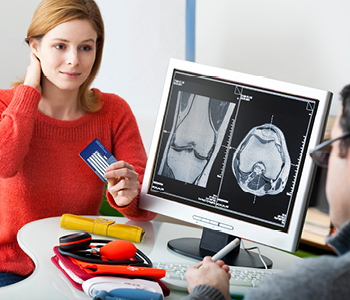 Ženska pri zdravniku v tujini uporablja evropsko zdravstveno izkaznico