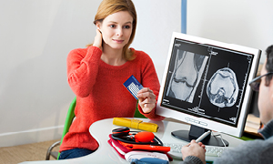 Ženska pri zdravniku v tujini uporablja evropsko zdravstveno izkaznico