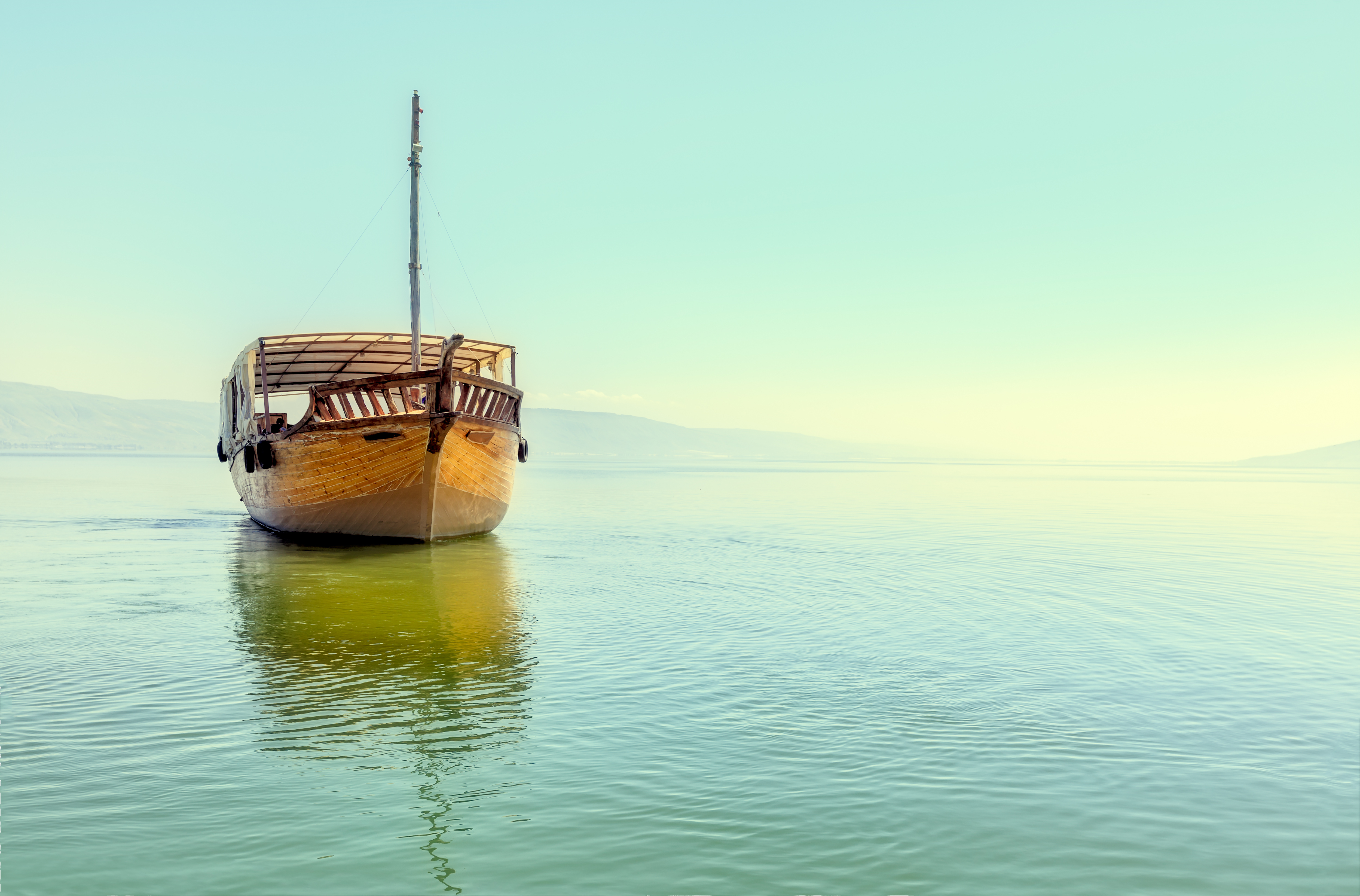 A boat glides on the calm waters of a serene sea.