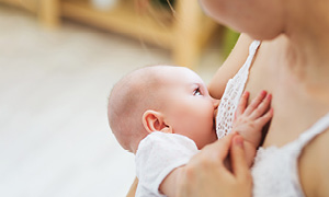 Prikupen dojenček se doji v materinem naročju, mama pa zaupa, da bo popil dovolj mleka