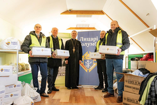 Members of Sts. Borys and Hlib Council 17740 in Fastiv, joined by their chaplain, Father Vitalii Martsyniuk, prepare care pack ages for distribution at their parish Mercy Center.