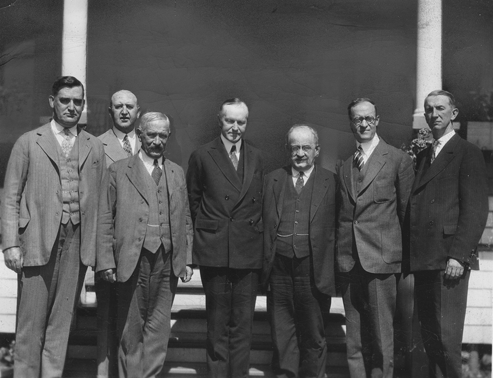 Pictured left to right are Supreme Advocate Luke E. Hart, Deputy Supreme Knight Martin Carmody, Supreme Knight James A. Flaherty, President Coolidge, Supreme Secretary William J. McGinley, Supreme Director William C. Prout, and Assistant Supreme Secretary John Conway.