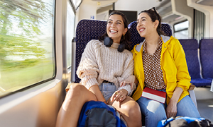 Dekleti odkrivata Evropo z vlakom in uživata v lepih razgledih trajnostnega in udobnega potovanja.