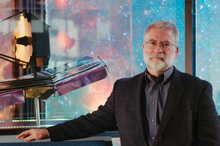 Michael Menzel, lead systems engineer of the James Webb Space Telescope, stands beside a model of the telescope at NASA’s Goddard Space Flight Center