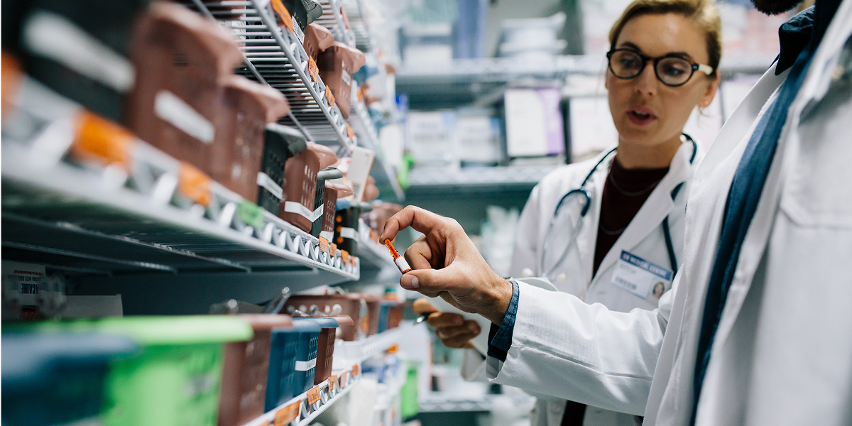 Two doctors in pharmacy, selecting medication