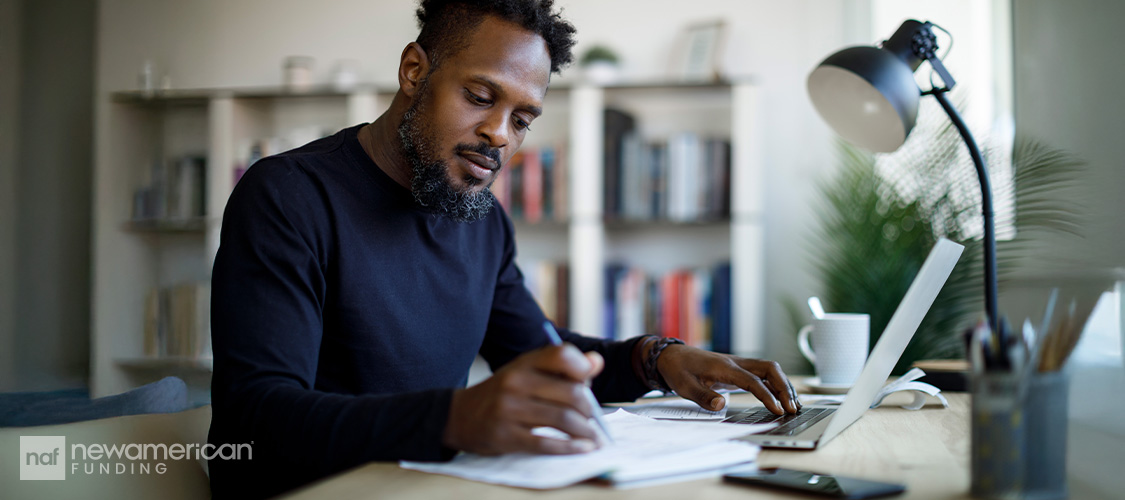 A man sitting at a desk doing paperwork.